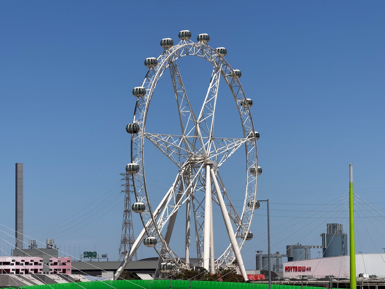 The iconic Melbourne Star Observation Wheel under a bright blue sky in Melbourne, Australia.