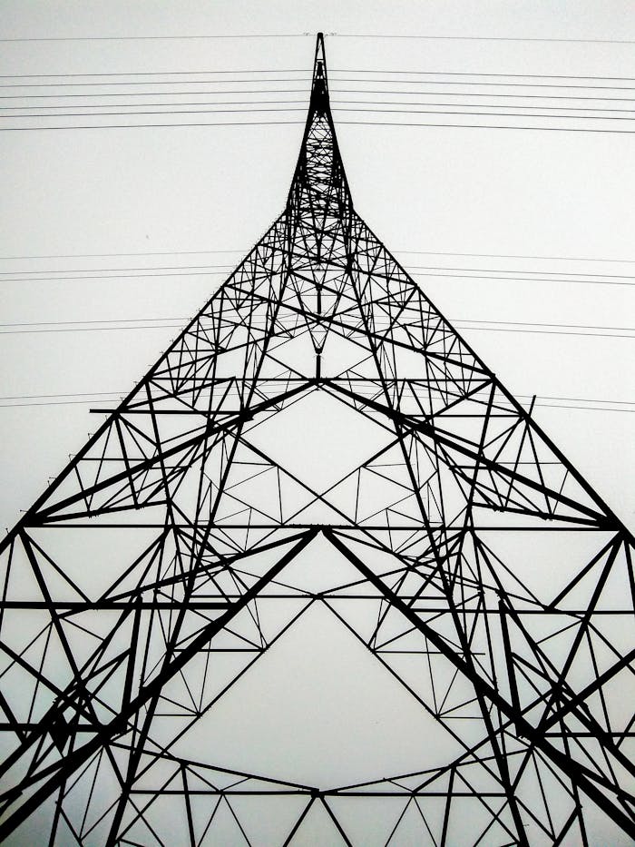 Perspective view of a high voltage transmission tower showcasing its intricate steel framework and power lines.