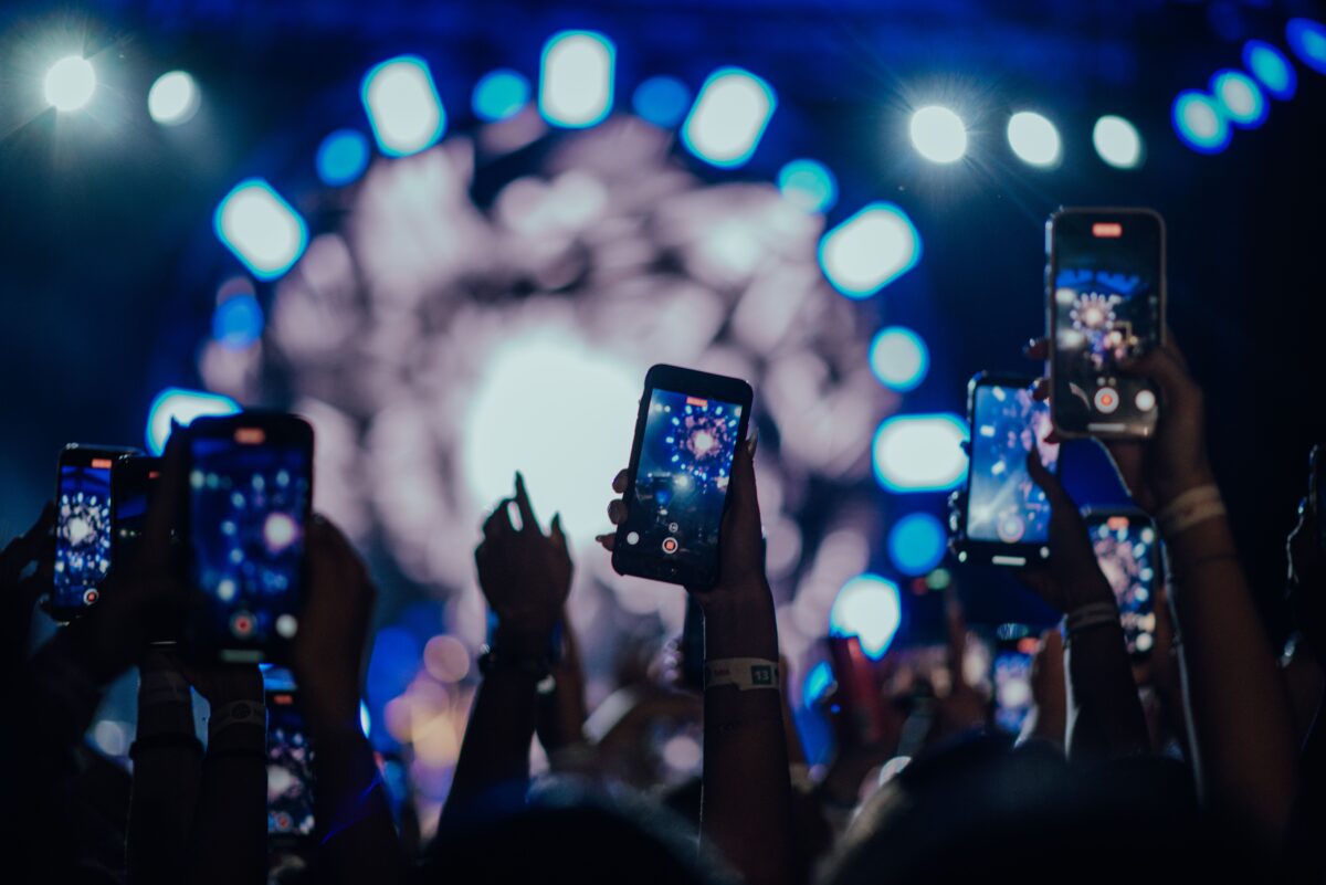 pexels photo 15338774 15338774 Attendees film a vibrant concert stage with smartphones capturing the mesmerizing lights.