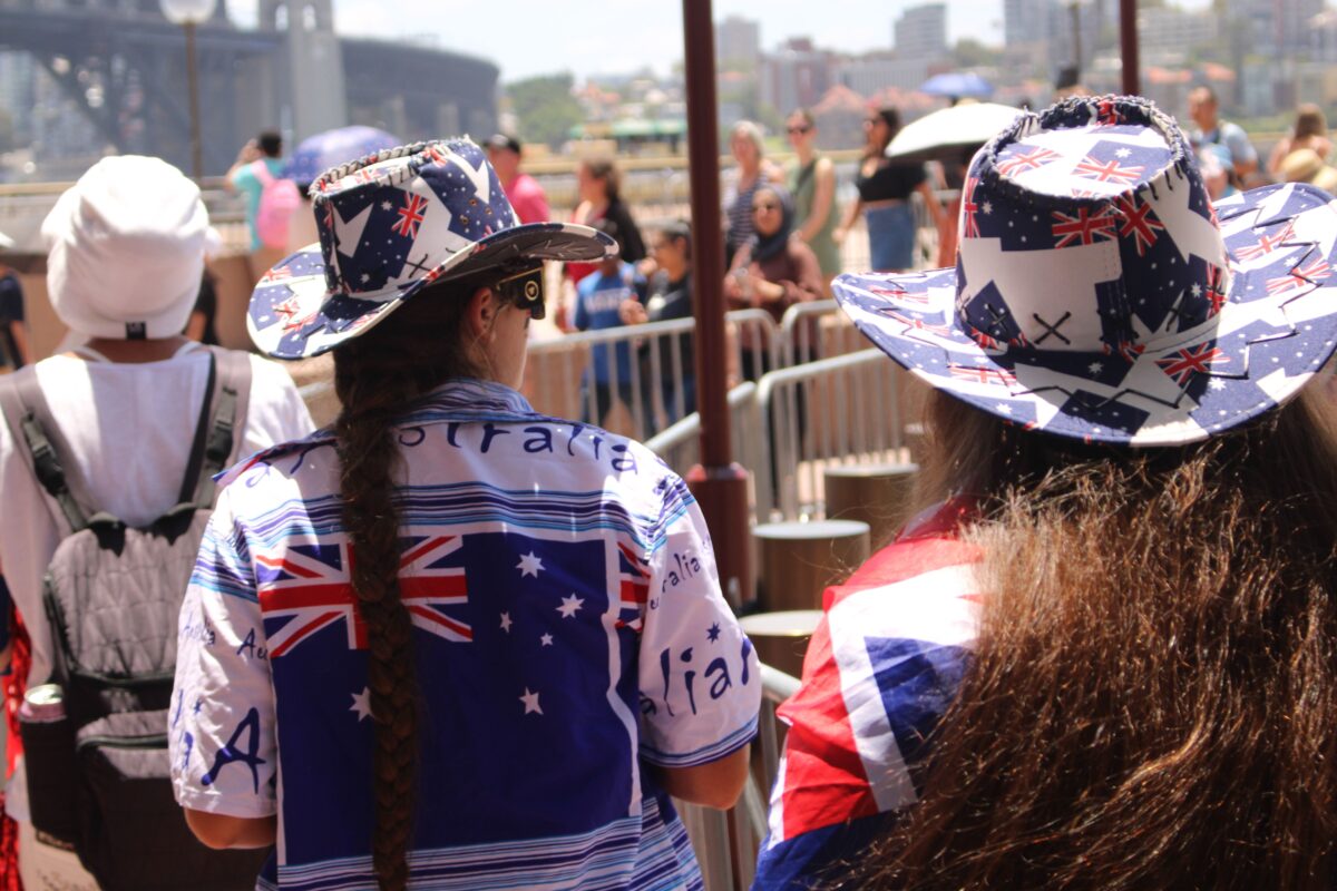 pexels photo 30444438 30444438 People in Australian attire celebrating at Sydney Harbour under bright sunlight.