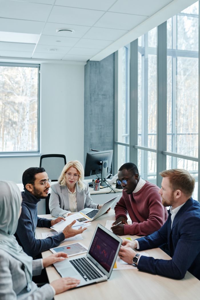 Home A diverse group of colleagues working together on a project in a bright, modern office environment.
