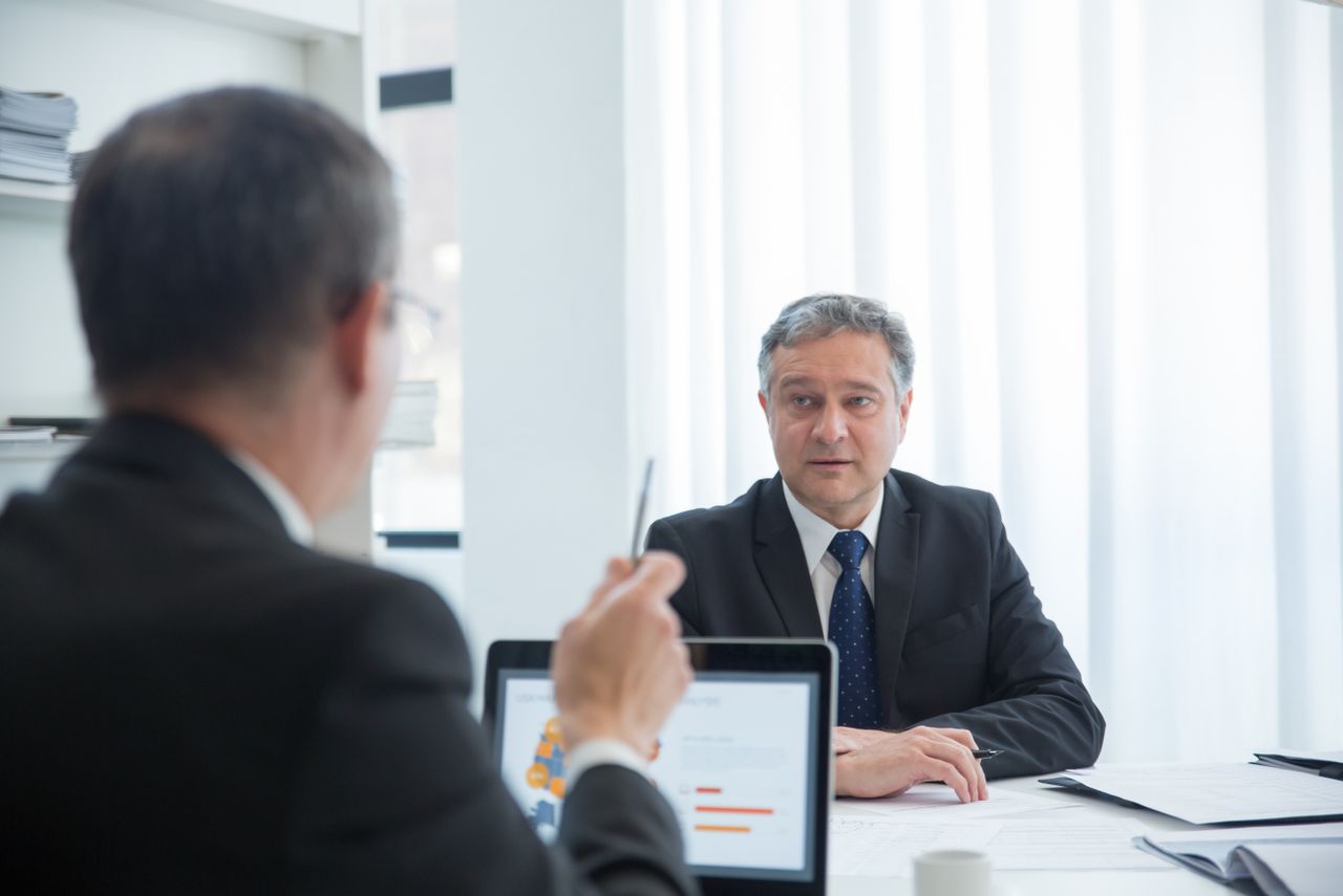 Home Business professionals in a focused discussion during an office meeting.